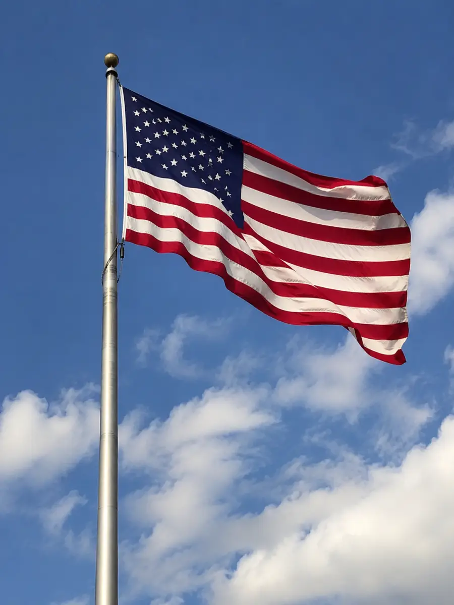 American flag flying against a blue sky.